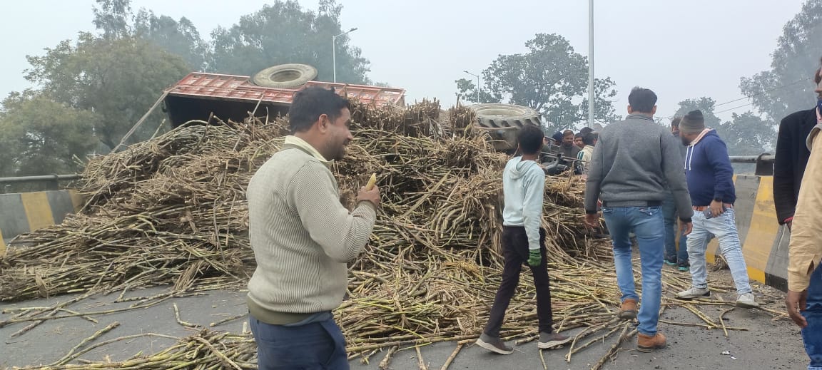 ओवर ब्रिज पर गन्ना लदी ट्रैक्टर ट्राली पलटी, बाल बाल बचे लोग